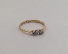 An 18 carat diamond three stone ring with platinum