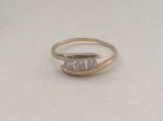 A 9 carat three stone crossover ring. Approx. 1.2