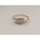 A 9 carat three stone crossover ring. Approx. 1.2