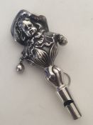 An unusual silver rattle in the form of a child wi