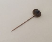 A cabochon garnet and gold stick pin with ball dec