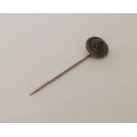 A cabochon garnet and gold stick pin with ball dec