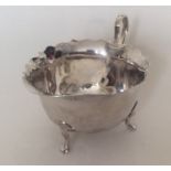 An Edwardian silver cream jug with card cut rim. A