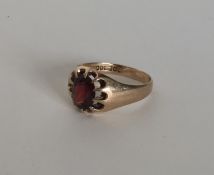 A gent's garnet single stone gypsy set ring in 9 c