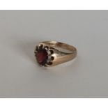 A gent's garnet single stone gypsy set ring in 9 c