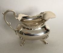 A silver cream jug with card cut rim. London. Appr