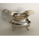 A silver cream jug with card cut rim. London. Appr