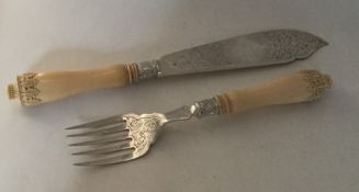 A pair of ivory and silver engraved fish servers w