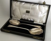 A pair of silver salad servers with panelled bowls