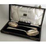 A pair of silver salad servers with panelled bowls