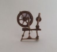 A 9 carat brooch in the form of a spinning wheel.