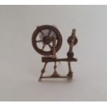 A 9 carat brooch in the form of a spinning wheel.