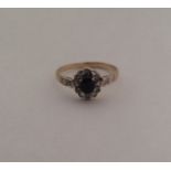 A sapphire and diamond circular cluster ring. Appr