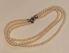 A triple string of pearl beads with gold clasp. Ap