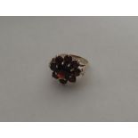 A 9 carat garnet circular cluster ring in claw mou