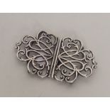 A pierced silver buckle with scroll decoration. Lo