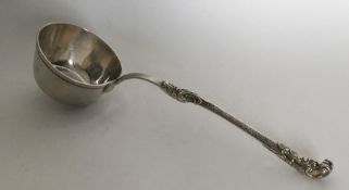 A Continental silver ladle with scroll handle. Pun