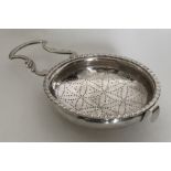 A large silver lemon strainer with pierced bowl an