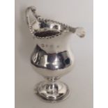 A Georgian silver cream jug with crimped rim to ba