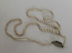 A graduated imitation seed pearl necklace with sapphire conc