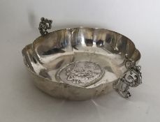 A heavy silver two handled cup with scroll decorat