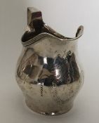 A Georgian silver cream jug with scroll decoration