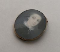 An oval gold miniature depicting a lady mounted as