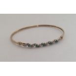 A 9 carat emerald and diamond twist bangle. Approx