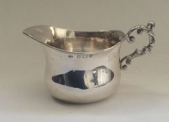 A small silver cream jug with scroll handle. Birmi