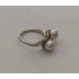 A pearl two stone crossover ring in 14 carat gold.