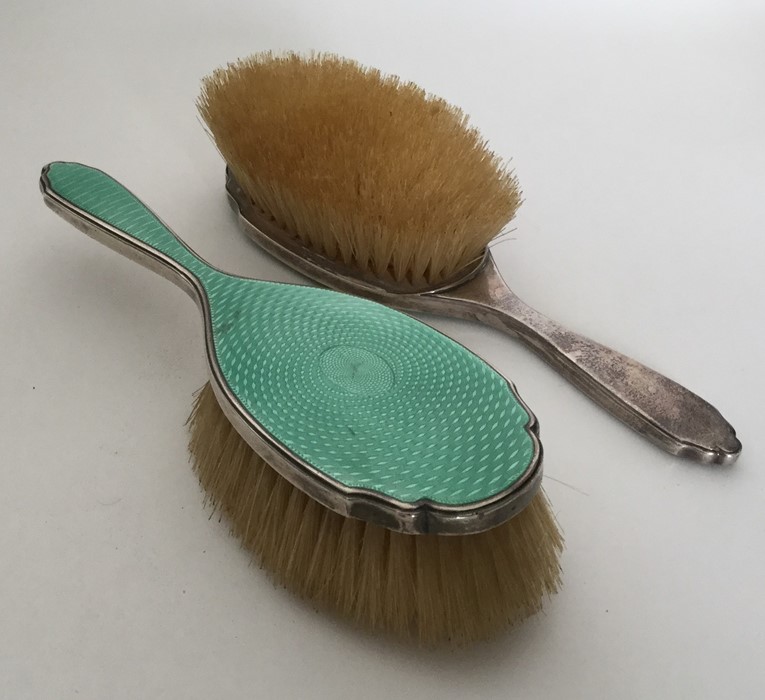 A pair of attractive green enamelled hairbrushes w