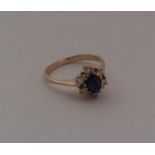 An 18 carat sapphire and diamond cluster ring. App