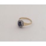 An 18 carat sapphire and diamond oval cluster ring