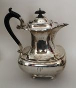 A stylish silver hot water pot of baluster form on