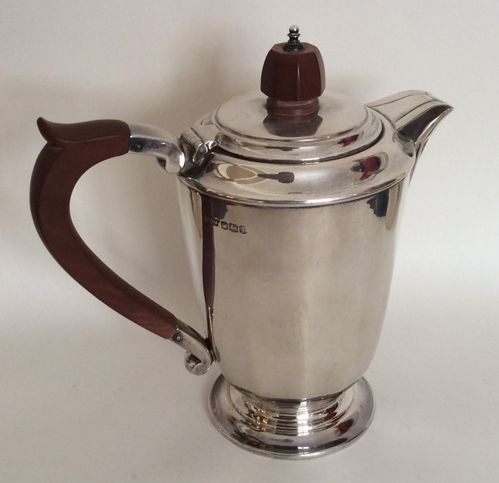 A heavy silver panelled water jug on pedestal foot