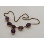 A large amethyst six stone necklace in claw mounts