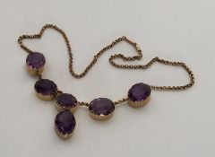 A large amethyst six stone necklace in claw mounts