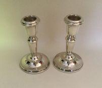 A pair of modern silver tapering candlesticks with