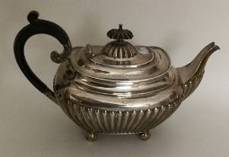 A small silver half fluted teapot on ball feet. Sh