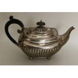 A small silver half fluted teapot on ball feet. Sh