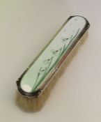 A silver and enamel hairbrush depicting stylish sn