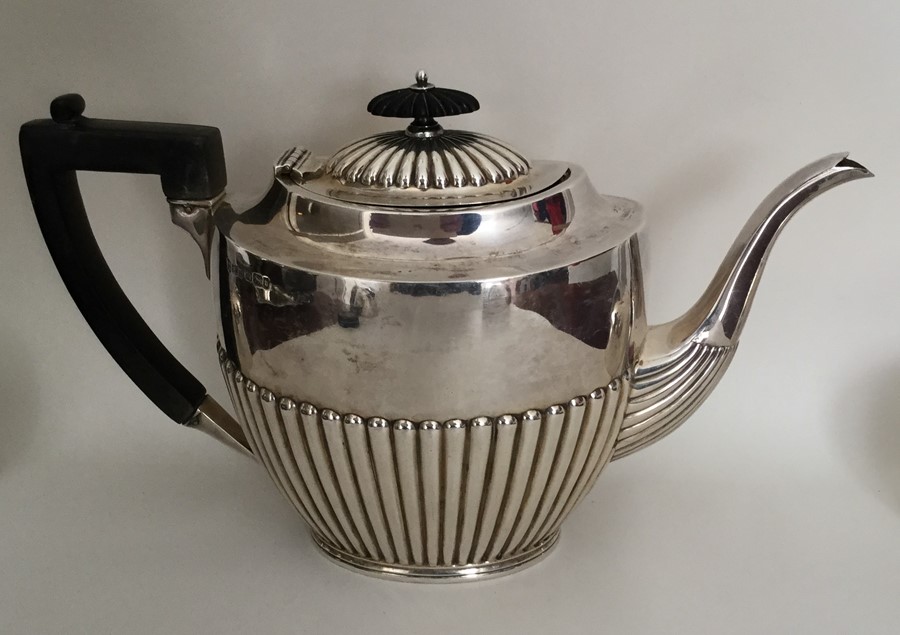 A large silver half fluted teapot with reeded deco