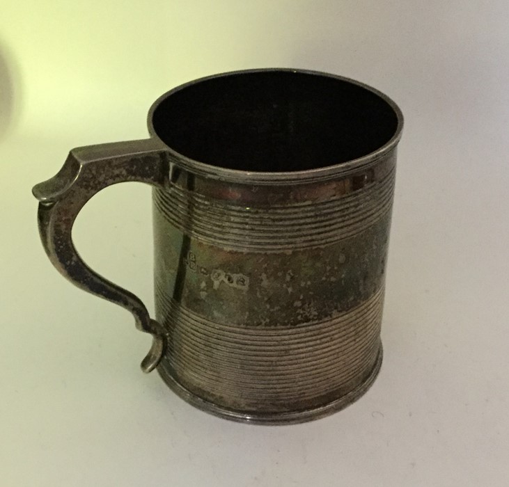 A Georgian silver tapering mug with reeded decorat