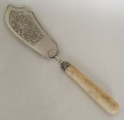 A George III silver fish slice with ivory handle.
