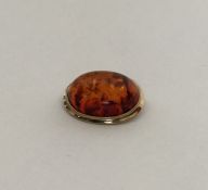 An amber oval brooch in gold frame. Approx. 6 gram