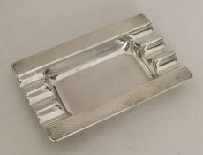 A silver Art Deco ashtray with engine turned decor