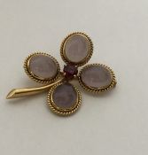 A heavy moonstone and gold brooch in the form of