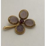 A heavy moonstone and gold brooch in the form of