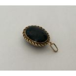 An unusual oval gold blood stone locket with rope