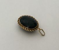 An unusual oval gold blood stone locket with rope